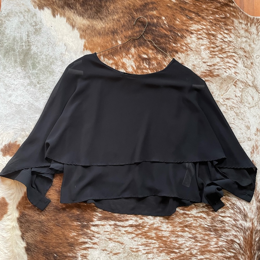 Black, flowy blouse with cap like sleeves.